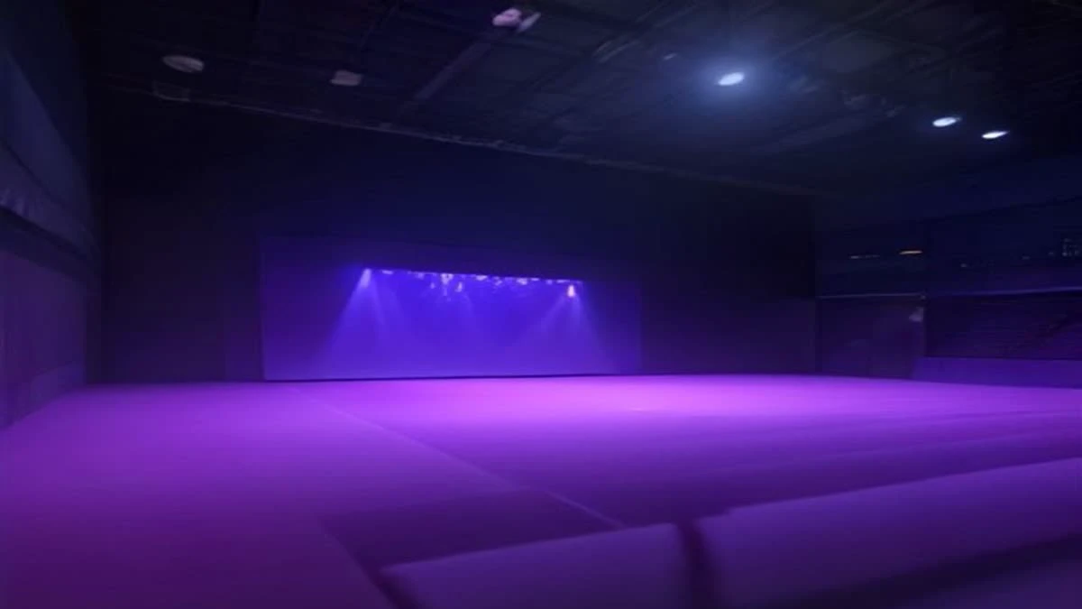 An esports arena stage lit by purple spotlights with rows of empty seats